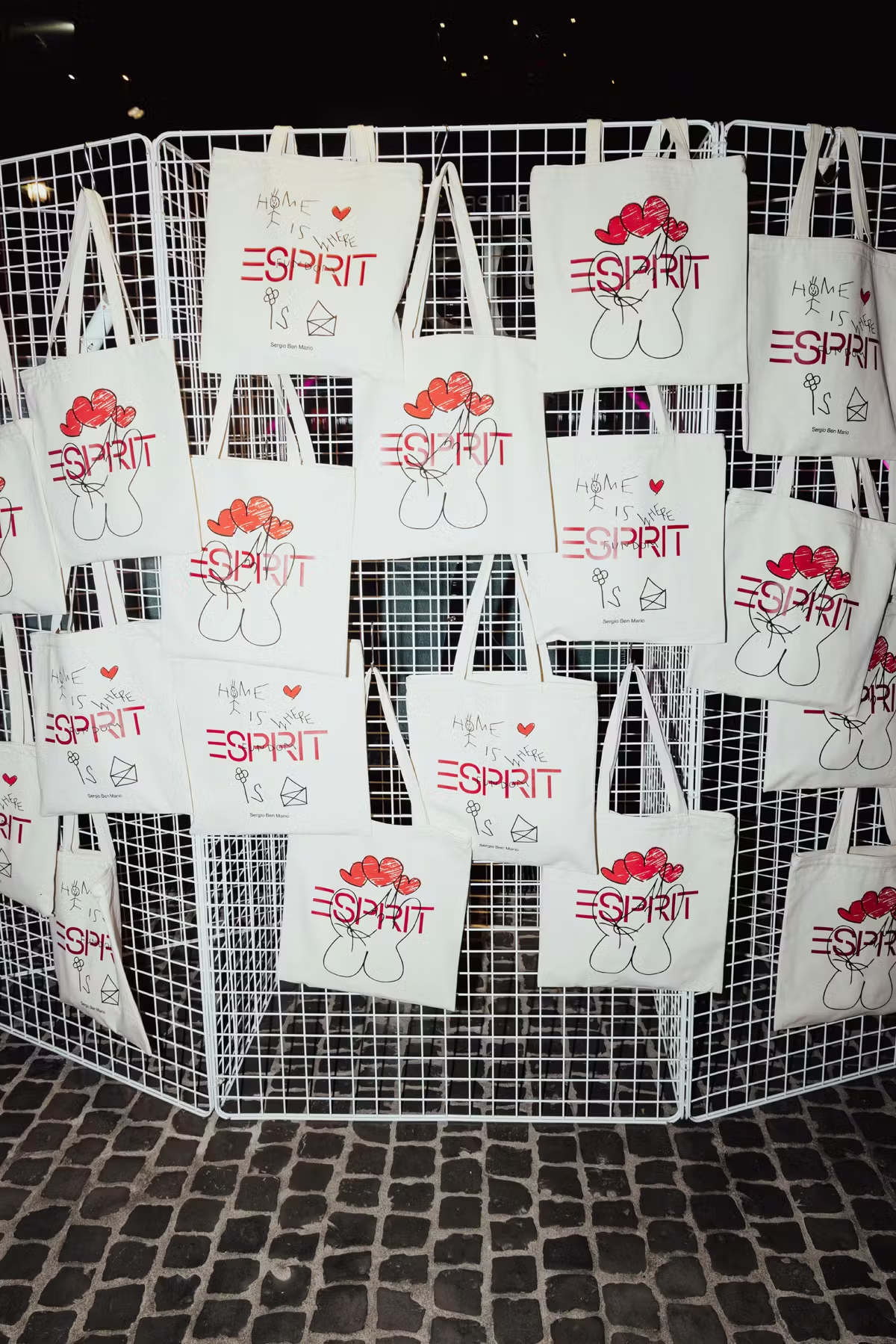 Esprit branded canvas tote bags hanging on a wire grid display